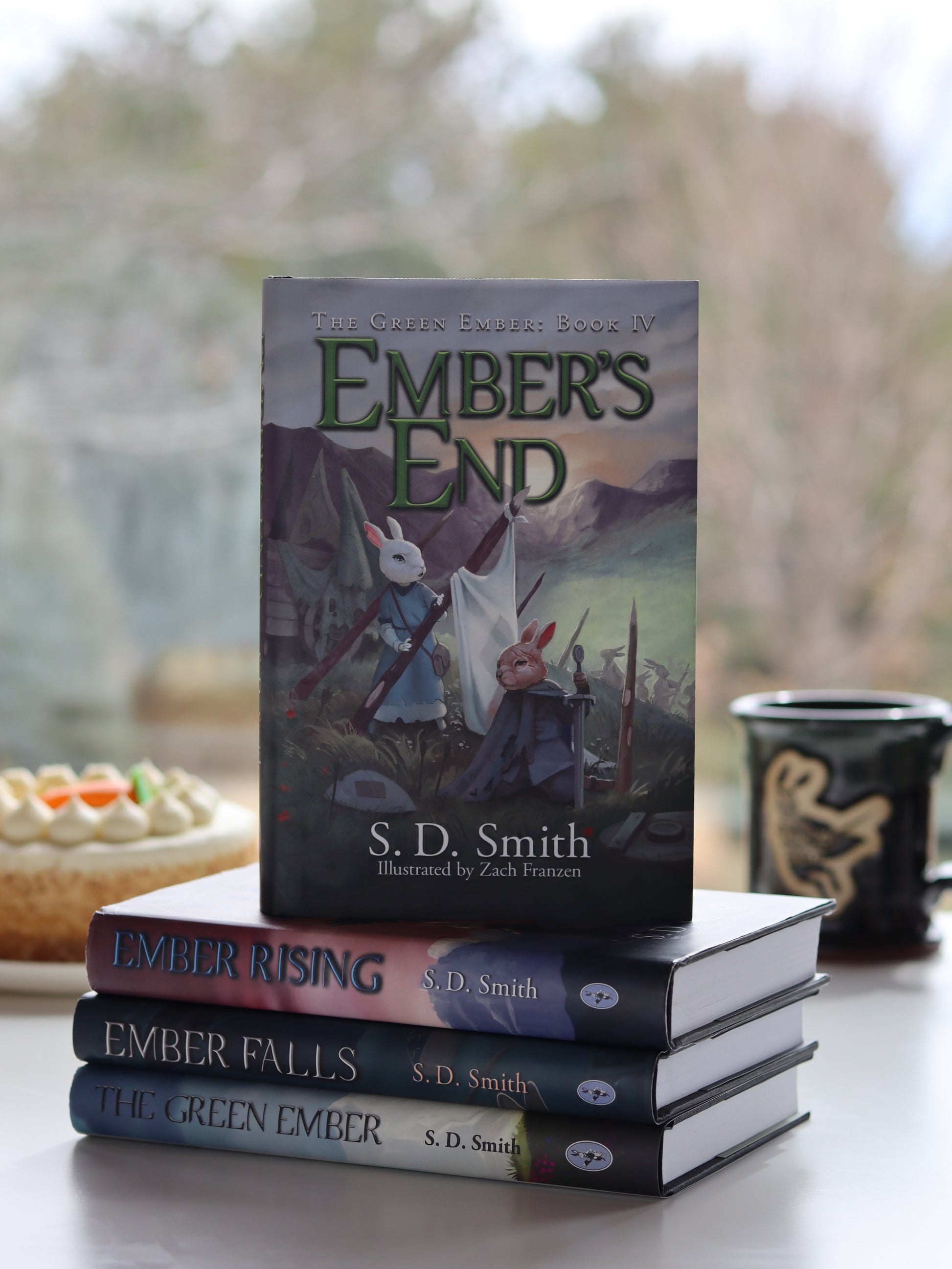 Stack of books titled 'Ember's End', 'Ember Rising', 'Ember Falls', and 'Green Ember' by S.D.